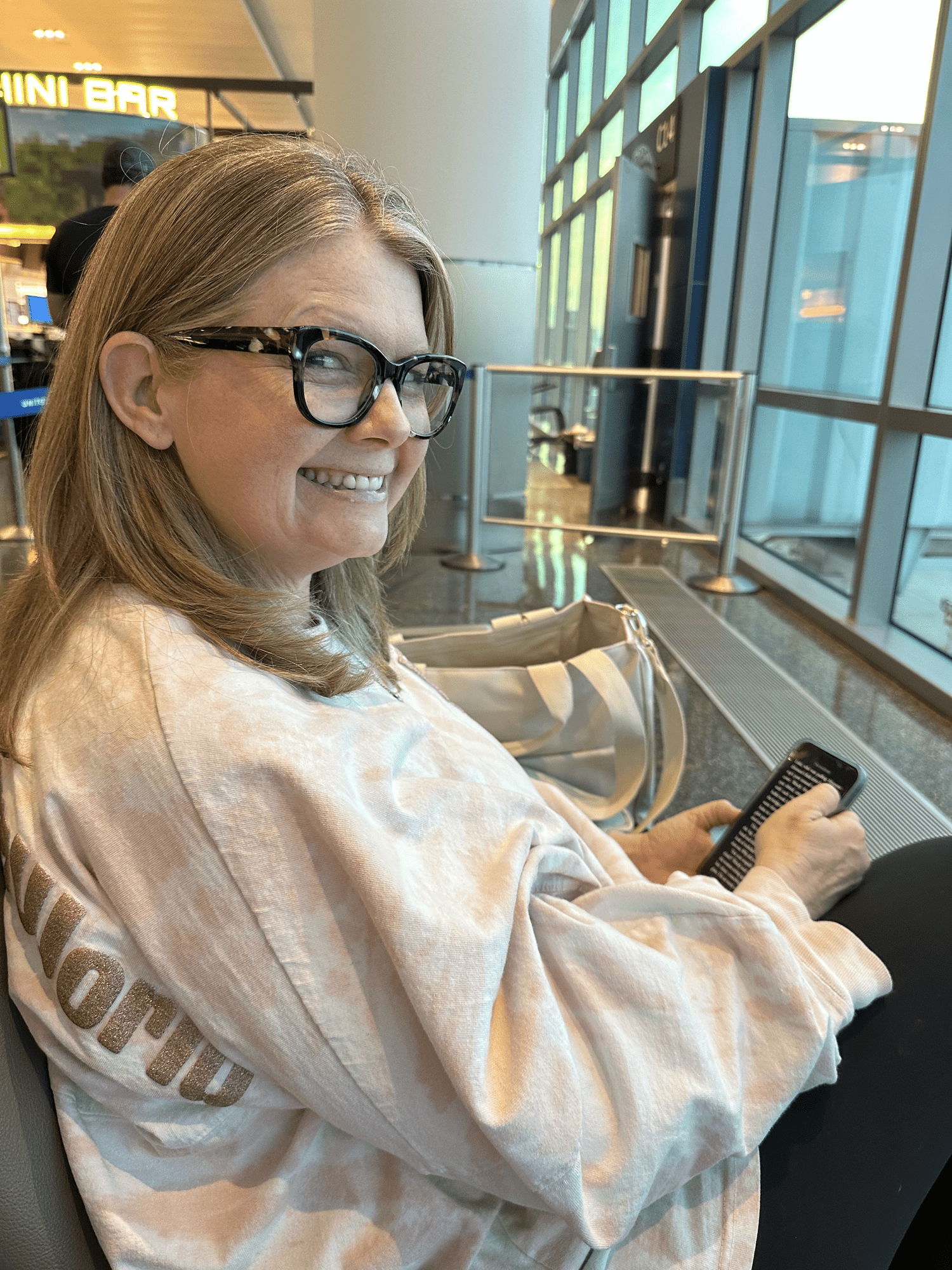 Personal Travel Planner Brandie cannot keep from smiling while watching the airplanes taking off and landing. She is about to get on one herself!
